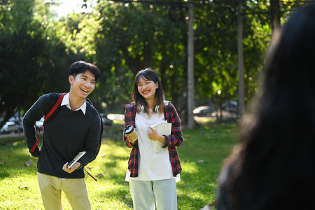 大学朋友在校园里散步，下课后休息并与他人交谈。
