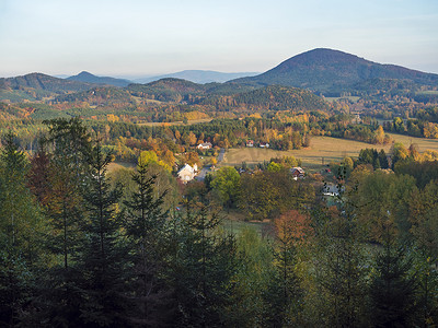 从 luzicke hory 的 Travnik 小村庄鸟瞰，Lusatian 山脉，秋季色彩斑斓的落叶和针叶林，黄金时段的绿色山丘