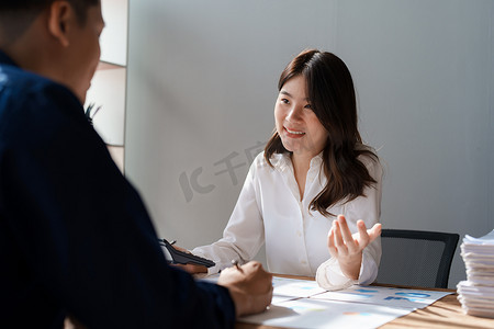 会计师检查财务报表或计算税表的计算器收入，女商人坐着和同事一起工作，讨论办公室的办公桌。