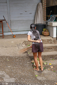 畚箕摄影照片_妇女清洁服务用扫帚和畚箕清理道路。