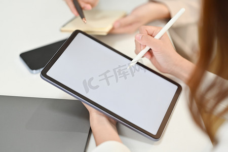 创意女性拿着手写笔指向空白数字平板电脑屏幕的特写视图