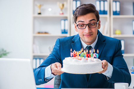 公司周年庆画摄影照片_年轻商人独自在办公室庆祝生日