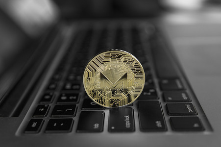 monero摄影照片_笔记本电脑上的 Monero 硬币符号，未来概念金融货币，加密货币符号。