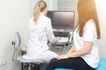 女内分泌学家在超声办公室对一名女性患者进行超声检查。