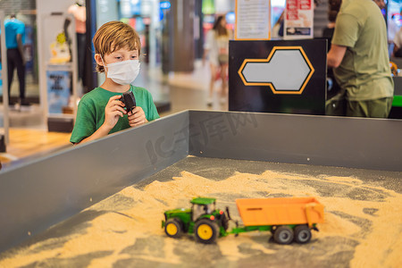 可爱可爱的小孩在商场里玩遥控器上的玩具。