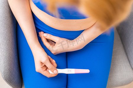 验孕棒怀孕摄影照片_手中拿着验孕棒的女人的俯视图