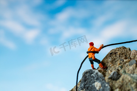 微型人物：攀登岩石的徒步旅行者。