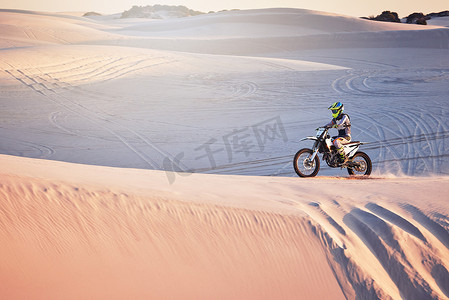 沙漠、摩托越野和极限摩托车运动，一名男子在非洲沙丘上健身。