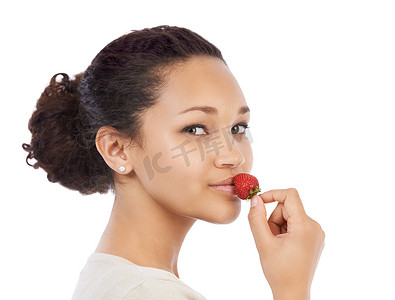 嗯，这个已经成熟了……年轻女子将新鲜的草莓压在她的嘴唇上-在白色上被隔离。