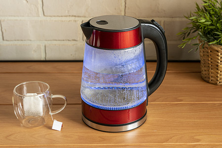 电热水壶摄影照片_双层玻璃壁时尚茶杯和电茶壶