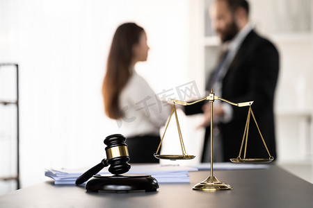 将法律符号聚焦在模糊的律师背景上。