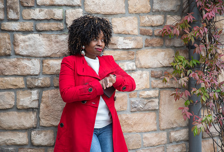 严肃的非洲裔美国女性不耐烦地看着她家附近的手表