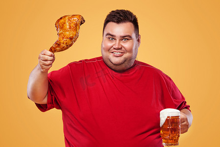 在慕尼黑啤酒节上不是运动型胖子，在黄色背景下喝啤酒和吃鸡腿。