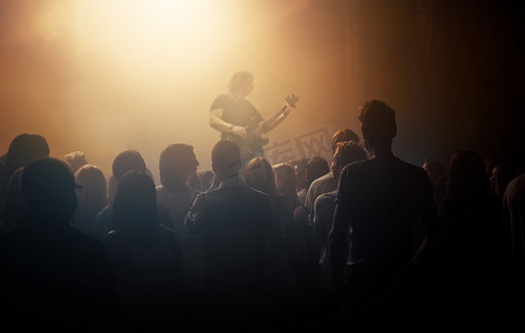 黑暗的人群、音乐家和人们在音乐会上参加吉他表演、音乐节和乐队。