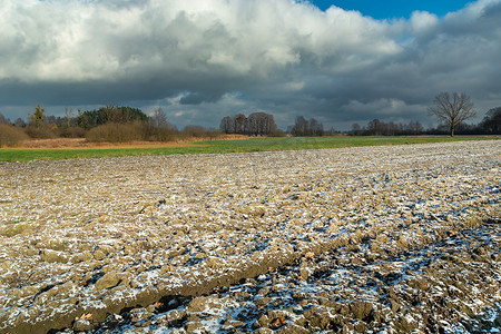 砥砺深耕摄影照片_犁过的田地和多云的天空上的小雪