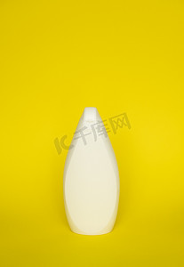 黄色背景上的白色洗发水瓶或沐浴露。