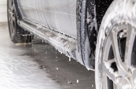 银车在洗车时的特写镜头，上面有肥皂污渍和水滴