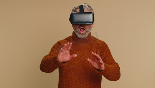 使用虚拟现实耳机头盔的老人玩模拟游戏应用，观看视频内容