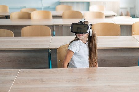 在教室里戴着虚拟现实眼镜的白人女学生。