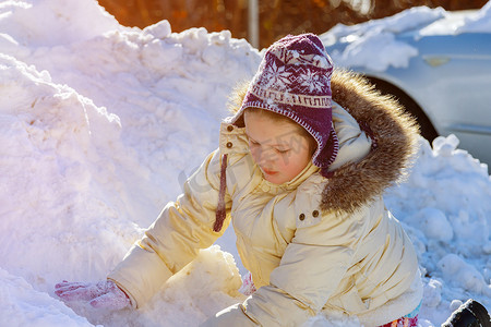 雪地里玩耍摄影照片_冬天在雪地里玩耍的可爱白人小女孩