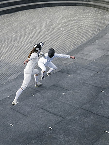 两名运动员在英国伦敦 Scoop 圆形剧场的台阶上击剑，视野开阔