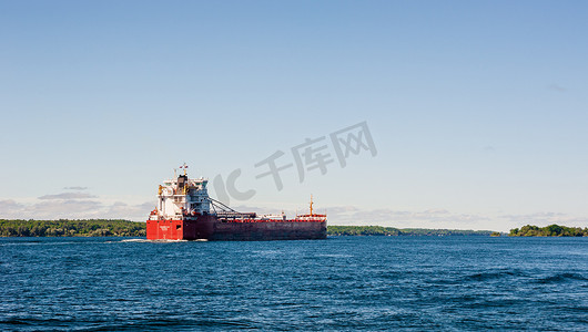 货船沿着加拿大安大略省布罗克维尔附近宽阔的河流行驶。