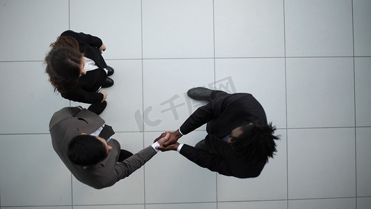 商业伙伴握手作为团结的象征，从上往下看