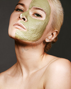 应用绿色面膜的美丽女人。