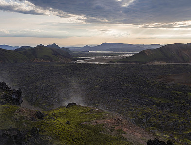 气孔摄影照片_冰岛高地 Fjallabak 自然保护区日出时 Landmannalaugar 的熔岩场景观和地热喷气孔、河流三角洲和 Rhyolit 山