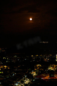 万圣节满月背景摄影照片_夜空中明亮的满月在城市上空
