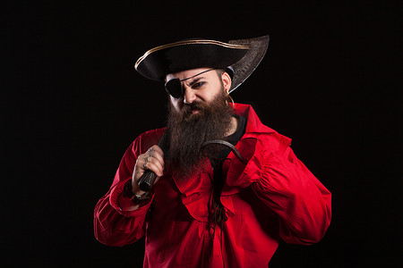 愤怒的男人穿着海盗船长服装参加万圣节，肩上扛着斧头
