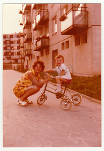 复古照片显示母亲和她的儿子骑三轮车，大约 1974 年。
