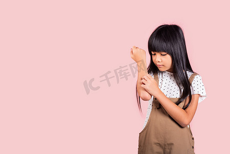 被叮咬摄影照片_10 岁的亚洲小孩被蚊子叮咬抓痒手臂