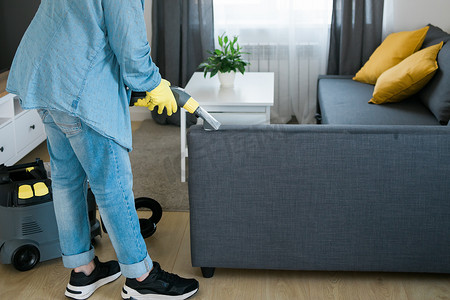 清洁服务公司员工使用专业设备清除公寓家具上的污垢。