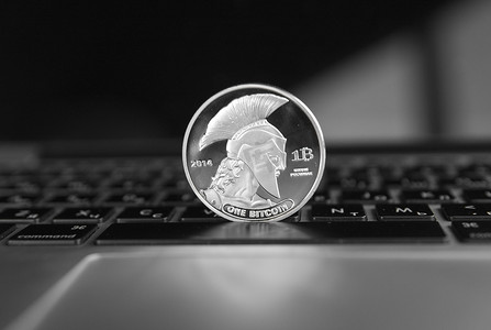 泰坦摄影照片_笔记本电脑键盘上的银泰坦加密硬币。
