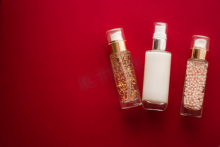 红色背景中的护肤化妆品和抗衰老美容产品、豪华护肤瓶、油、血清和面霜