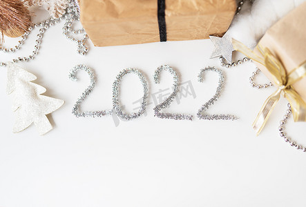 2022 年新年快乐。节日装饰 — 圣诞树、礼物、星星、金属丝。