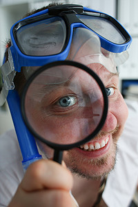一位戴着游泳镜、笑得开心的经理的画像透过放大镜看