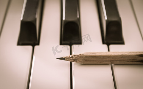 中电摄影照片_水平视图中电钢琴白键上的旧铅笔