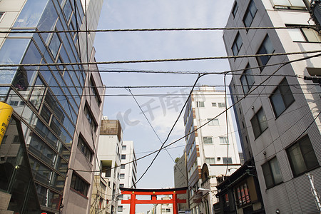 城市复牌摄影照片_多层建筑之间的电线和牌坊门
