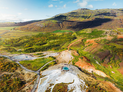 冰岛 Strokkur 间歇泉附近充满活力的绿色山丘和营养丰富的土地