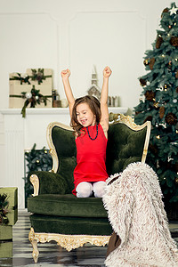 圣诞夜，小女孩在客厅的扶手椅上睡着了，等待圣诞老人。