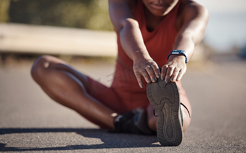 黑人女性在城市街道上伸展脚、跑步和健身，开始跑步时进行热身和有氧运动。