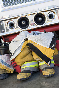 应急车辆摄影照片_在消防车旁边清空消防员的靴子和制服