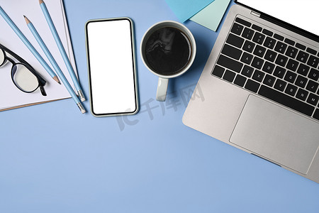 在蓝色背景上模拟手机、笔记本电脑和咖啡杯。