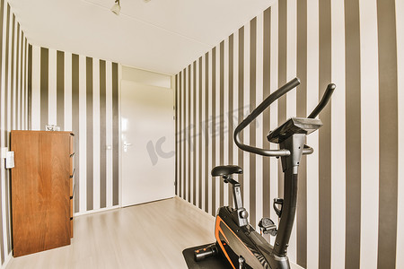 带健身脚踏车和条纹墙的健身房