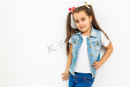 全身大小的少女漂亮可爱开朗可爱可爱时尚小女孩与卷曲辫子穿着正式的衬衫衬衫，蓝色短裙，思考。