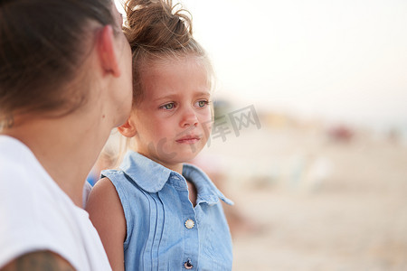 哭泣的小女孩母亲女儿夏天海滩。