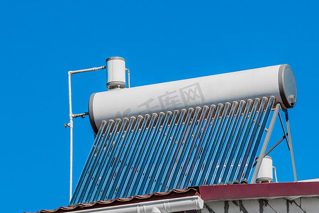 蓝天背景下某建筑屋顶的太阳能热水器。