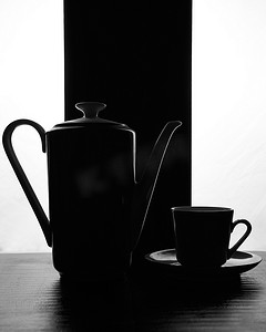 黑色白色背景中带碟子的概念水壶和杯子